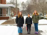Students stand on campus in the snow