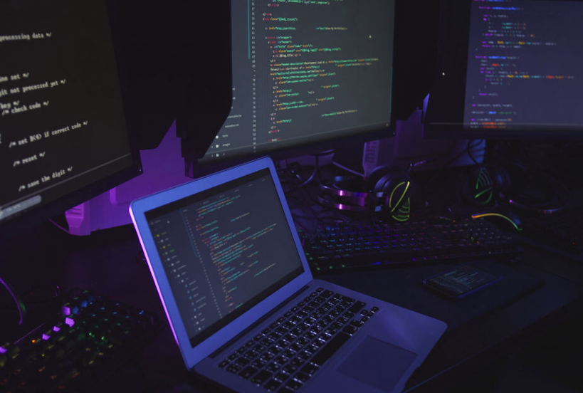 A dark room with many screens/computers